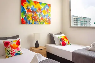 two beds in a room with a painting on the wall at Apartamento 2 dormitorios Morros Vistas. Piscina in Cartagena de Indias
