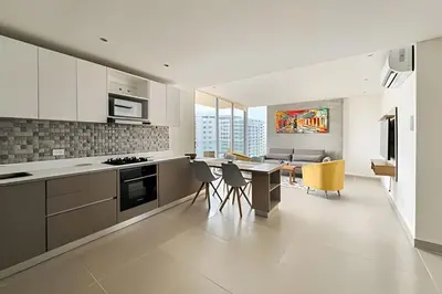 a kitchen and living room with a table and chairs at Apartamento 2 dormitorios Morros Vistas. Piscina in Cartagena de Indias