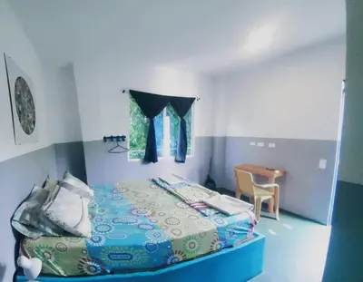a small bedroom with a bed and a table at Hotelito La Aventura, AC private WC rooms near the old town, no tax in Cartagena de Indias