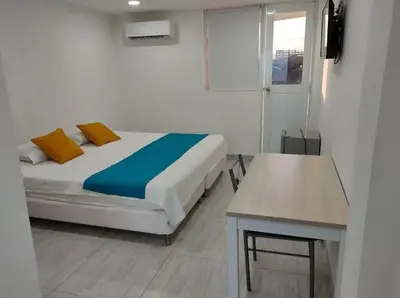 a bedroom with a bed and a table and a window at Hotel Doral Barranquilla in Barranquilla