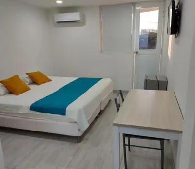 a bedroom with a bed and a table in it at Hotel Doral Barranquilla in Barranquilla
