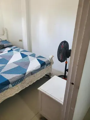 a bedroom with a bed and a fan and a table at Apartamentos y habitaciones cerca a marbella in Cartagena de Indias
