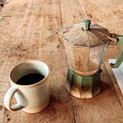a cup of coffee and a blender on a wooden table at Hostel Nugeku in Rincón
