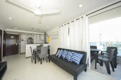 a living room with a couch and a dining room at Bienesweb Apartamentos Conquistador Premium in Cartagena de Indias
