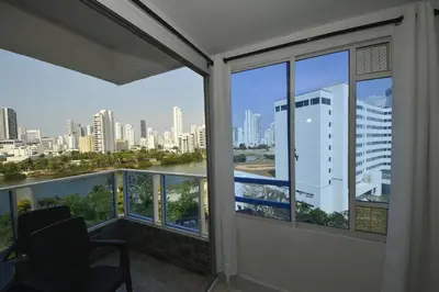 a balcony with a chair and a view of the city at Bienesweb Apartamentos Conquistador Premium in Cartagena de Indias