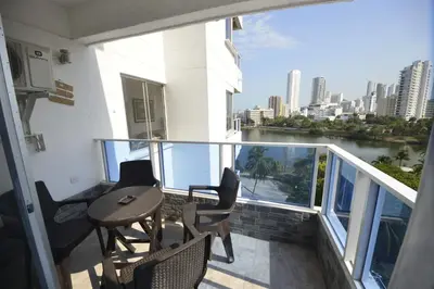 a balcony with a table and chairs and a river at Bienesweb Apartamentos Conquistador Premium in Cartagena de Indias