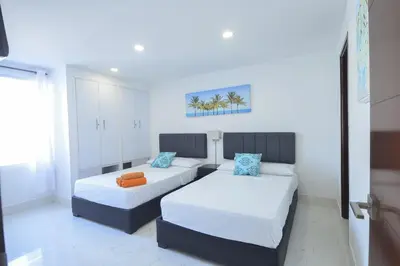 a bedroom with two beds and a couch at Bienesweb Apartamentos Conquistador Premium in Cartagena de Indias