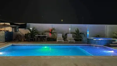 a swimming pool at night with a table and chairs at Cabaña Villa Linda in Juan de Acosta