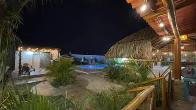 a resort with a swimming pool at night at Cabaña Villa Linda in Juan de Acosta