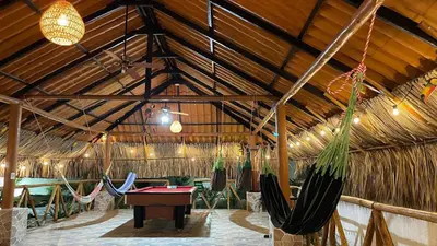 a room with hammocks and a ping pong table at Cabaña Villa Linda in Juan de Acosta