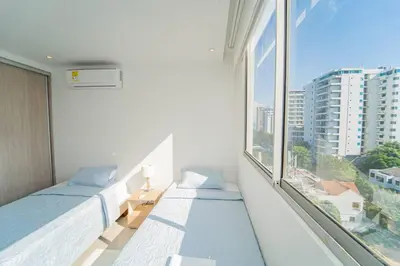 a white room with two beds and a large window at 1H Encanto Rentals @ Sunno Beach in Cartagena de Indias