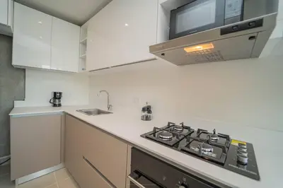a white kitchen with a stove and a sink at 1H Encanto Rentals @ Sunno Beach in Cartagena de Indias