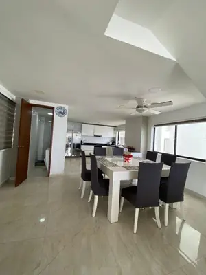 a dining room with a white table and black chairs at APTO DUPLEX MARINA DEL REY CARTAGENA in Cartagena de Indias