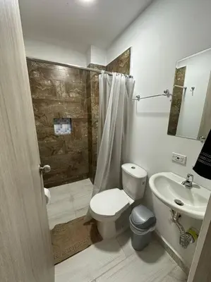 a bathroom with a toilet and a shower and a sink at Apto PB Palmar de los vientos in San Bernardo del Viento