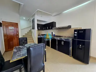 a kitchen with black appliances and a table with chairs at Penthouse Duplex Vista 360 Piso 23 in Cartagena de Indias