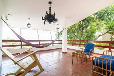 a room with a hammock and chairs on a balcony at El Refugio Beach House, Bello Horizonte, Santa Marta in Playa Dormida