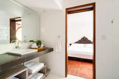 a bathroom with a sink and a mirror and a bed at El Refugio Beach House, Bello Horizonte, Santa Marta in Playa Dormida