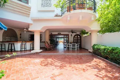 a house with a balcony and a patio at El Refugio Beach House, Bello Horizonte, Santa Marta in Playa Dormida