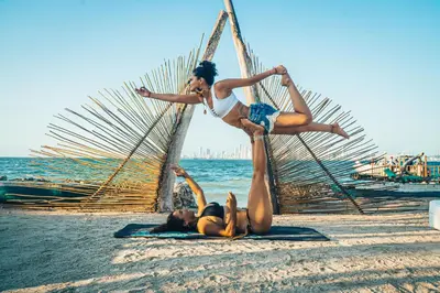 two women on the beach doing a trick at Namaste Beach Club & Hotel in Tierra Bomba