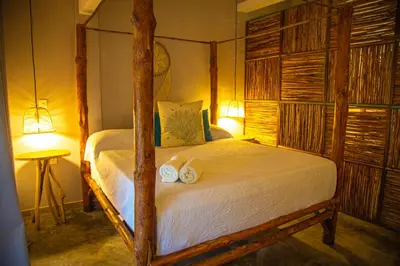a bedroom with a bed with two towels on it at Namaste Beach Club & Hotel in Tierra Bomba