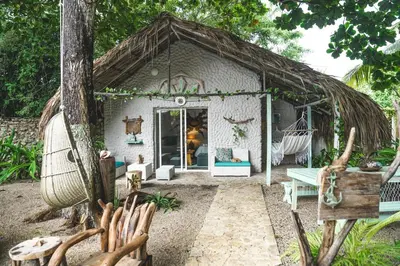 a small shack with a hammock in a yard at Namaste Beach Club & Hotel in Tierra Bomba