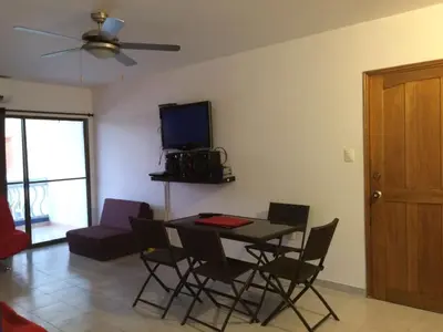 a living room with a table and chairs and a tv at Apt 311 Mar de leva in Santa Marta