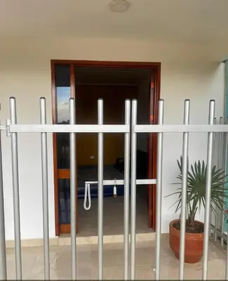 a fence with a potted plant in front of a bedroom at Casa Murillo in San Antero