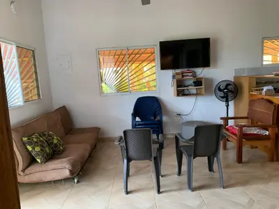 a living room with a couch and a table and chairs at Cabaña El Esplendor in San Bernardo del Viento
