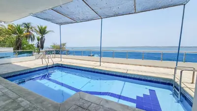 a swimming pool with a view of the ocean at El Laguito Cartagena - Apartamento 2 habitaciones acceso directo a playa in Cartagena de Indias