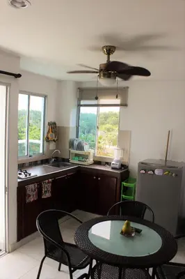 a kitchen with a table and chairs and a ceiling fan at Villa Patry Coveñas in Coveñas