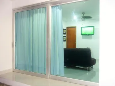 a living room with a sliding glass window with a couch at Villa Patry Coveñas in Coveñas