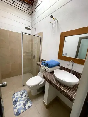 a bathroom with a sink and a toilet and a mirror at Cabañas La Española in Coveñas