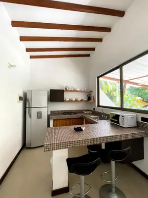 a kitchen with a counter and a refrigerator at Cabañas La Española in Coveñas