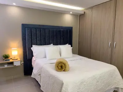 a bedroom with a bed with a teddy bear on it at Lujoso apartamento cerca al Aeropuerto y Ciudad Amurallada in Cartagena de Indias