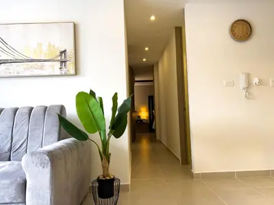 a living room with a couch and a plant at Lujoso apartamento cerca al Aeropuerto y Ciudad Amurallada in Cartagena de Indias