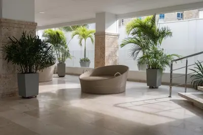 a lobby with potted plants and a chair at Sunshine 503 Beautiful SeaView 2Beds2bath w AC front Beach in Cartagena de Indias