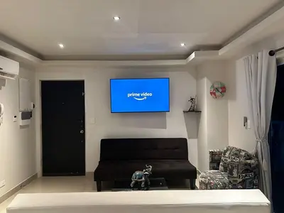 a living room with a couch and a tv on the wall at Sunshine 503 Beautiful SeaView 2Beds2bath w AC front Beach in Cartagena de Indias