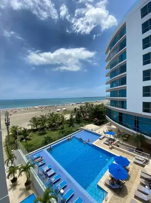 a hotel with a swimming pool next to a beach at Sunshine 503 Beautiful SeaView 2Beds2bath w AC front Beach in Cartagena de Indias