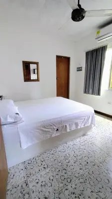 a bedroom with a large white bed with white sheets at Atardeceres Coveñas - Cabañas frente al mar in Puerto Viejo