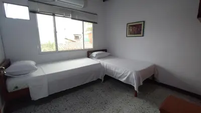 two beds in a room with a window at Atardeceres Coveñas - Cabañas frente al mar in Puerto Viejo