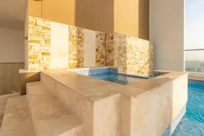 a pool in a room with a tile wall at Luxury Sea View Duplex in the Heart of the City in Cartagena de Indias