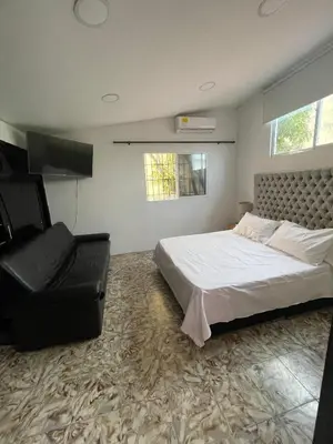 a bedroom with a bed and a chair in it at La casa de flor in Cartagena de Indias