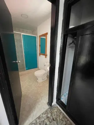 a bathroom with a toilet and a glass door at La casa de flor in Cartagena de Indias
