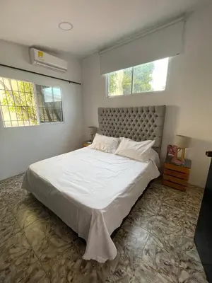 a bedroom with a large white bed with two windows at La casa de flor in Cartagena de Indias
