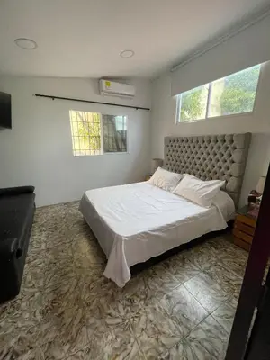 a bedroom with a large bed and two windows at La casa de flor in Cartagena de Indias
