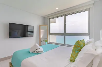 a bedroom with a bed with a large window at U-GO Palmetto Beach - Lujo Frente al Mar in Cartagena de Indias