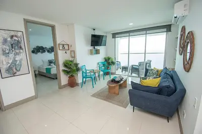 a living room with a blue couch and a table at U-GO Palmetto Beach - Lujo Frente al Mar in Cartagena de Indias