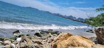 a beach with some rocks and the ocean at Apartamento Dorado Sunset in Santa Marta