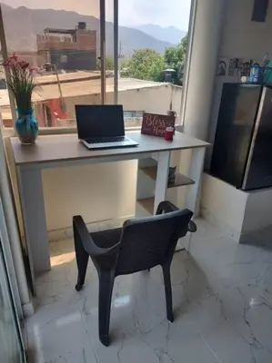 a desk with a laptop and a chair in front of a window at Apartamento Dorado Sunset in Santa Marta