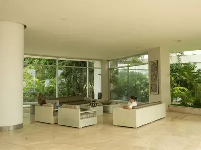 two people sitting on couches in a large room with windows at Morros 3 in Cartagena de Indias